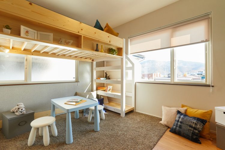 二段ベッドとテーブルやいす、ぬいぐるみがある子供部屋